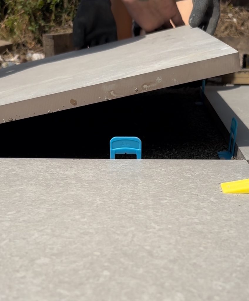 laying tiles on diy porcelain patio