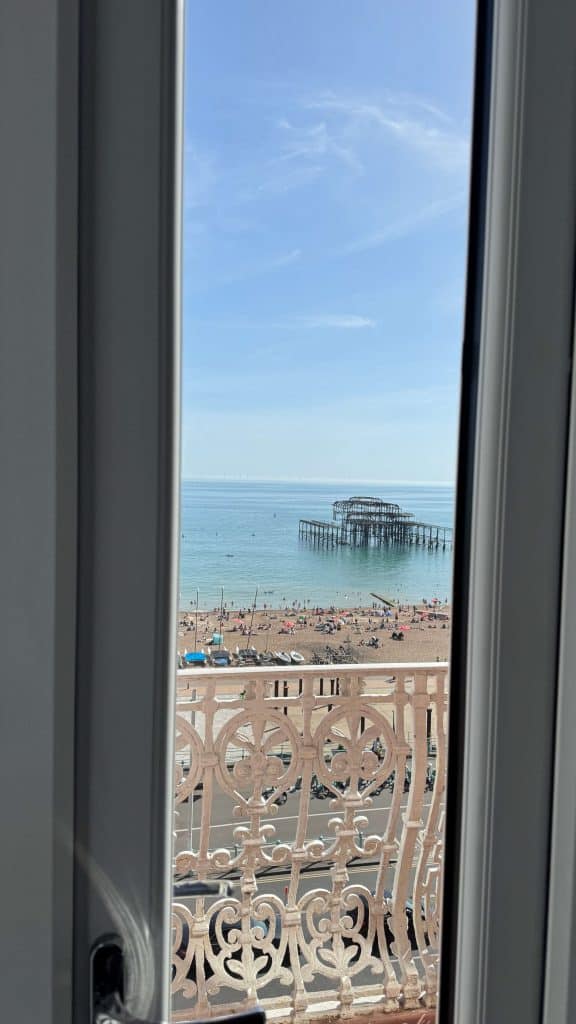 Scenic seaside view with pier and beach seen from a window.